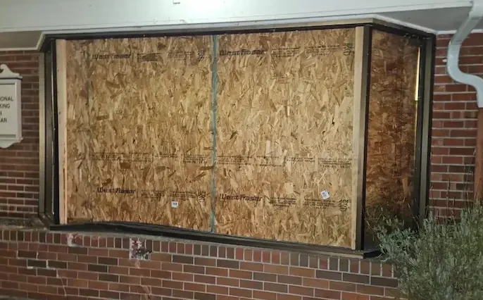 Storefront window board up service for a business in Seattle.